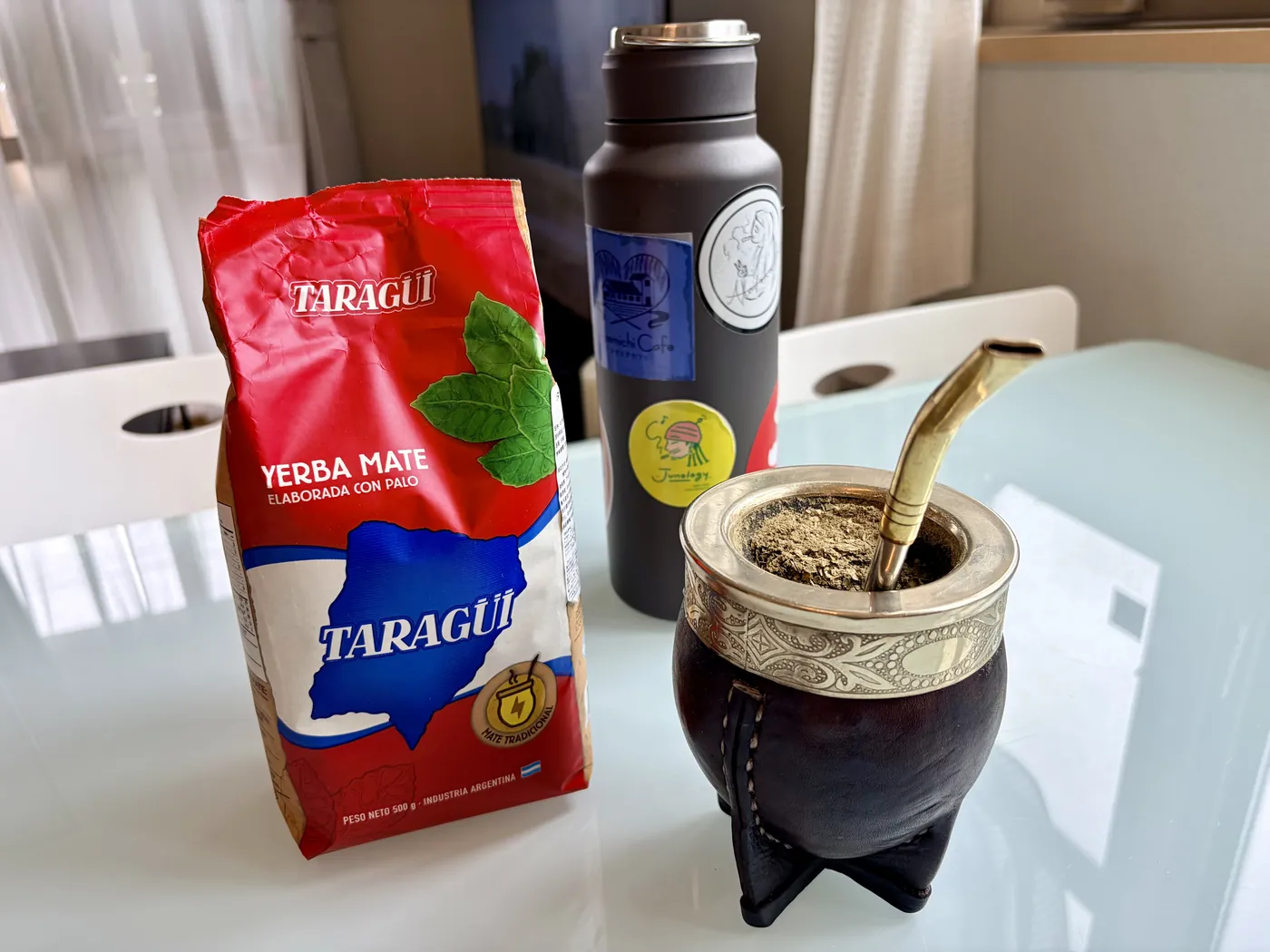 A table in Japan. A bag of Argentine yerba mate, a thermos, and a gourd packed with leaf beside its bombilla