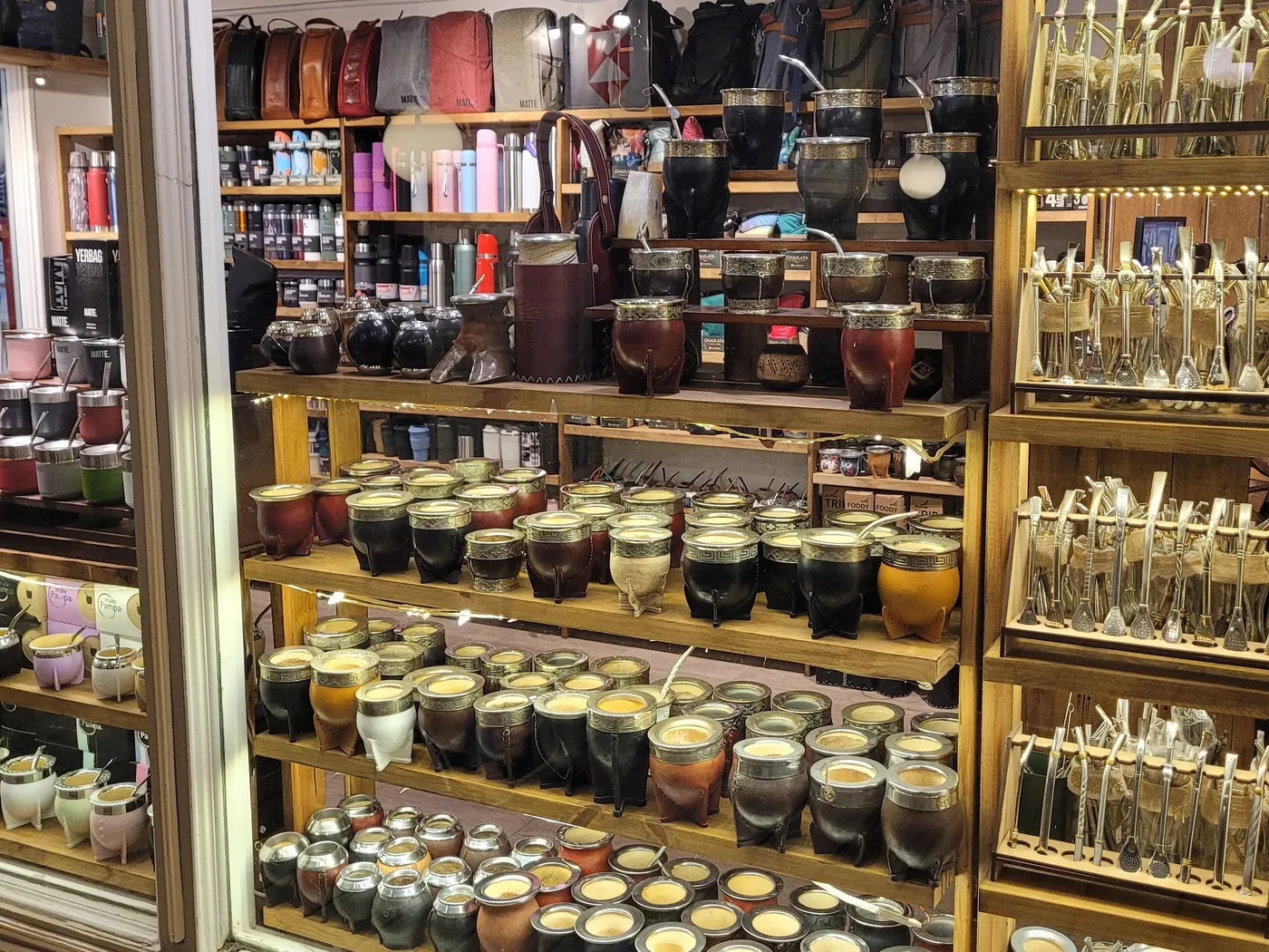 La fachada de una tienda que vende mates. Estantes llenos de calabazas vestidas de cuero y metal, y bombillas